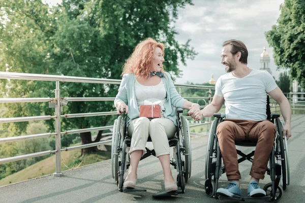 Verheugd vrouw houden de doos van de gift op knieën — Stockfoto