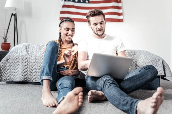 Positiv ung kvinna som håller ett kreditkort — Stockfoto