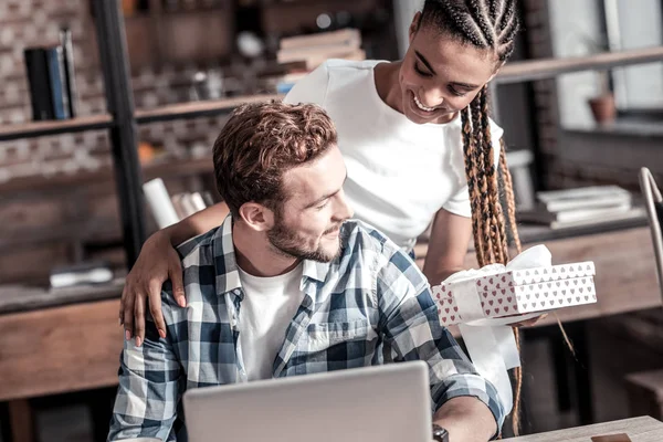 Mujer atractiva positiva sosteniendo un regalo — Foto de Stock