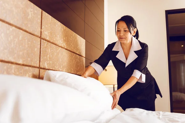 Professional maid making bed for guest — Stock Photo, Image