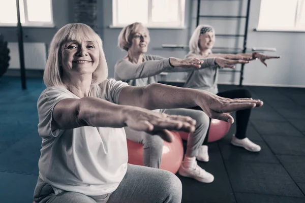 Alegres mujeres mayores haciendo ejercicio en las bolas de fitness — Foto de Stock