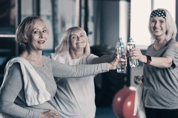 Tre donne sorridenti che si accarezzano bottiglie d'acqua — Foto Stock