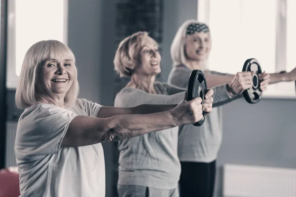 Señoras mayores que llevan a cabo entrenamiento de disco de peso — Foto de Stock