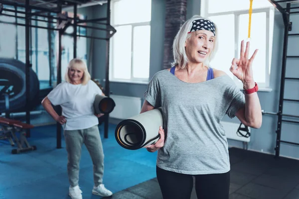 Spor salonunda ok işareti işaret pozitif kadın kıdemli — Stok fotoğraf