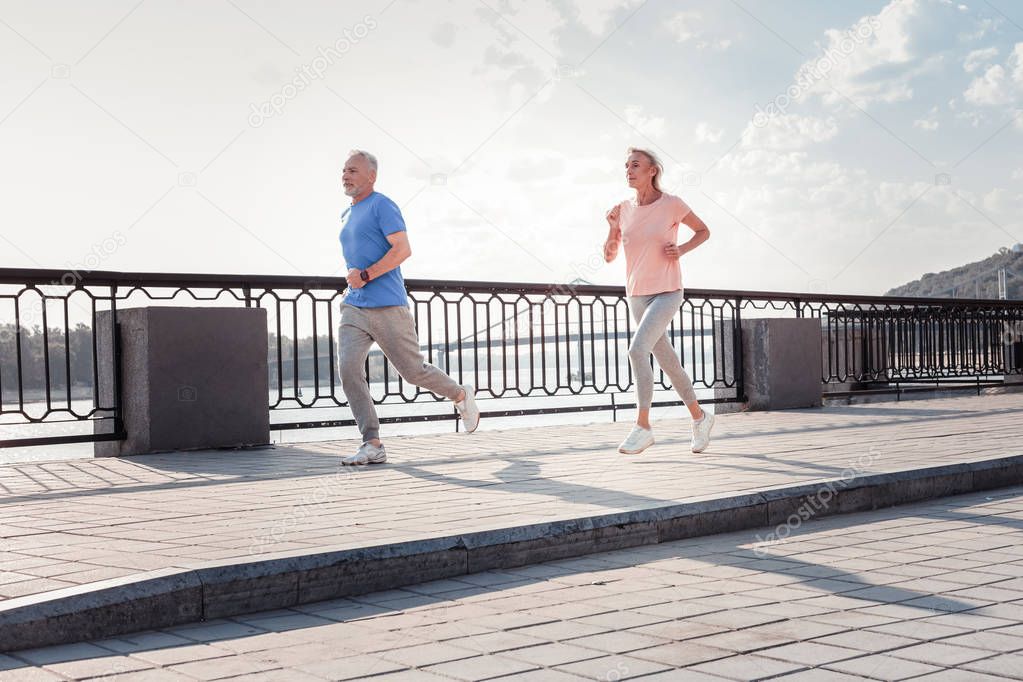 Senior sporting couple running and felling god themselves.