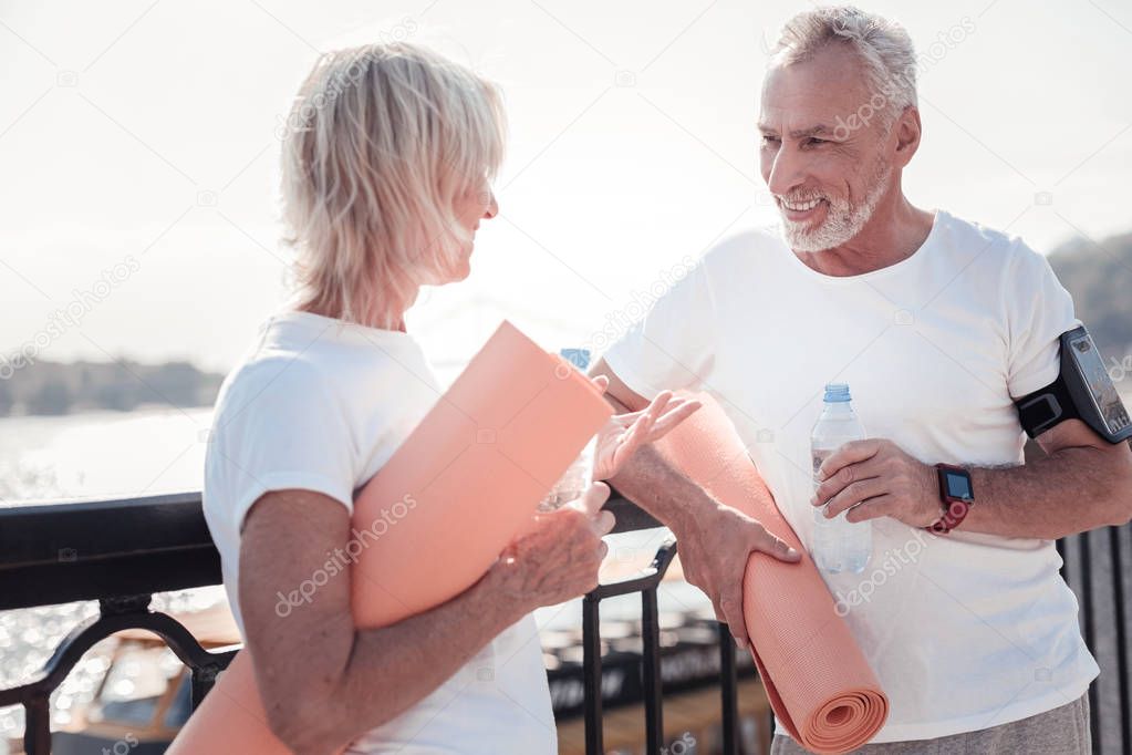 Handsome unshaken man standing and drinking water.