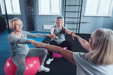 Neşeli olgun kadın fitness topları ile egzersiz sırasında elele