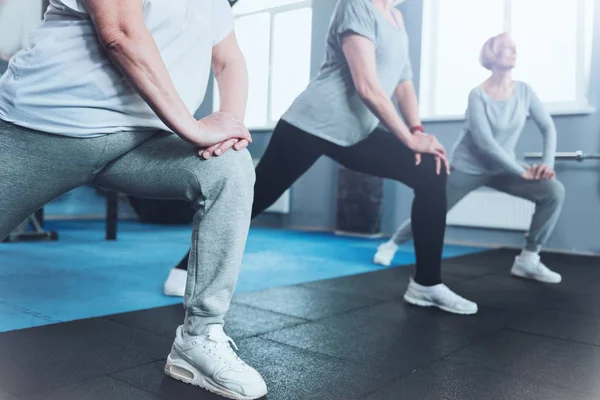 Nära upp tittar på pensionerade kvinnor utfallet på fitness club — Stockfoto