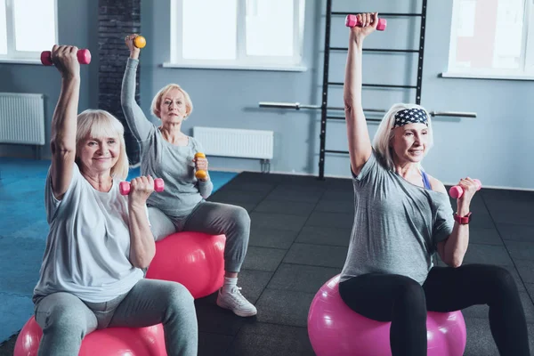 Grupo de señoras mayores activas entrenando con pesas en el gimnasio — Foto de Stock