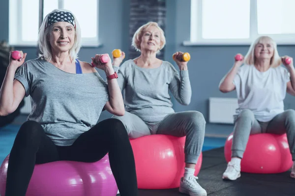 Mulheres aposentadas ativas durante a aula de exercício em grupo — Fotografia de Stock