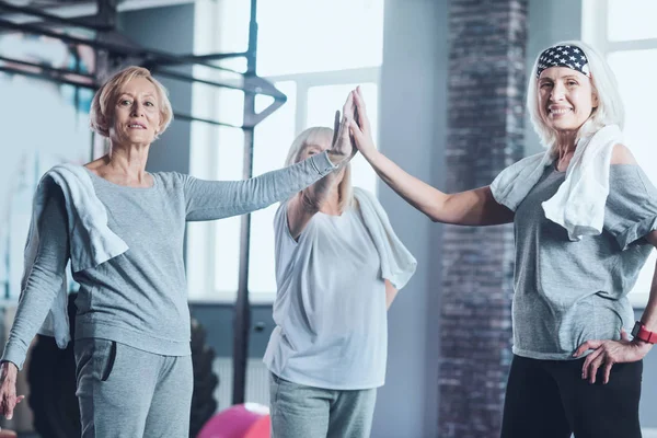 Mujeres maduras uniendo sus manos en el gimnasio — Foto de Stock