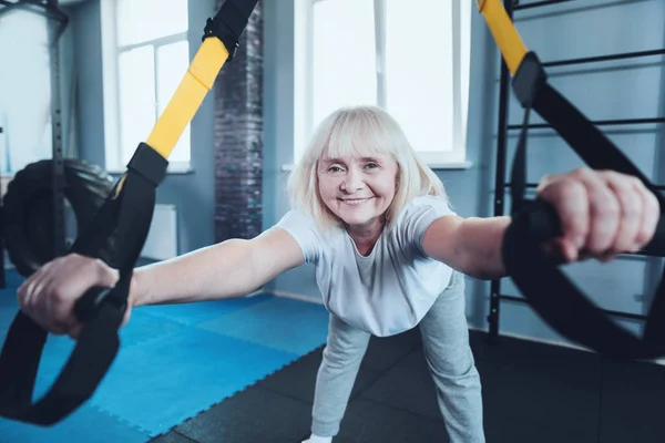 Positiv mogen kvinna ler in i kameran medan du tränar på gym — Stockfoto