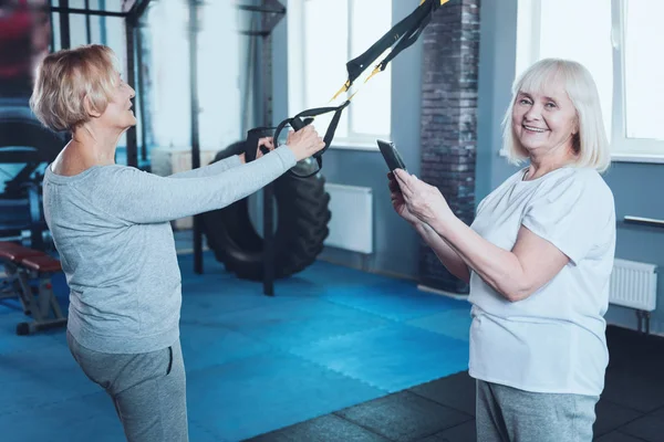 Üst düzey bayan arkadaş arkasında uzanan yakınındaki gülümseyen tablet bilgisayar ile