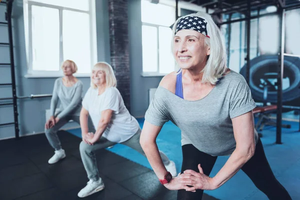 Mulheres idosas de mente positiva fazendo aquecimento no clube de fitness — Fotografia de Stock