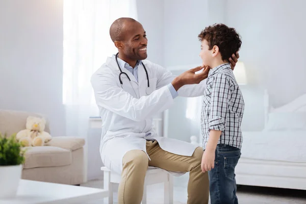 Pleasant male doctor checking boys tonsils — Stock Photo, Image