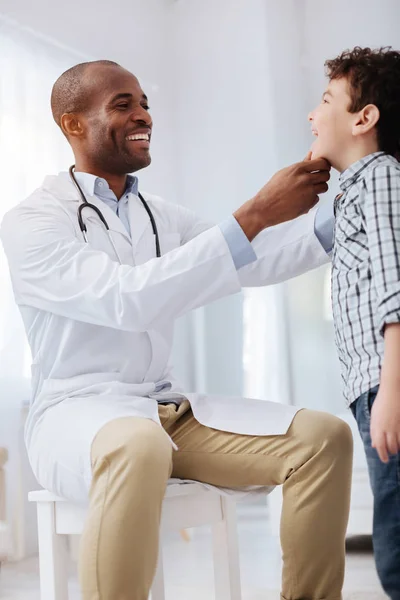Vigoroso médico masculino examinando los niños garganta —  Fotos de Stock