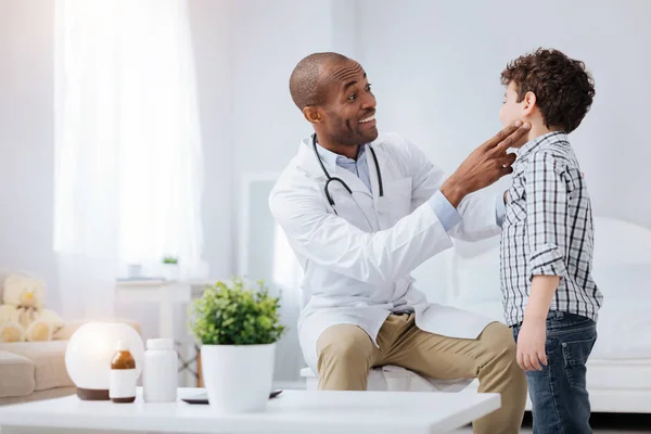 Divertido médico masculino examinando los niños amígdalas — Foto de Stock