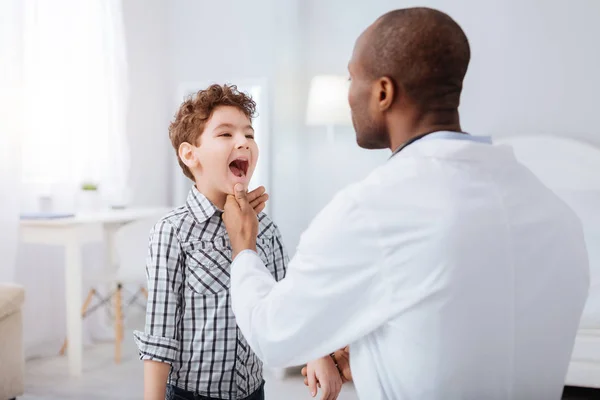 Niño pequeño abriendo la boca para el médico masculino —  Fotos de Stock