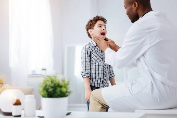 Afro American doctor tocando amígdalas de niños — Foto de Stock