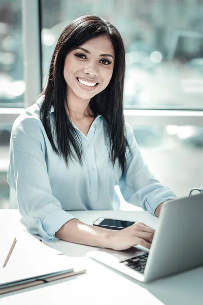 Trevliga vackra kvinnan leende och använder den bärbara datorn. — Stockfoto