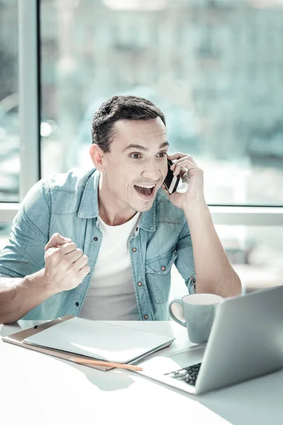 Sorprendido hombre sorprendido sonriendo y teniendo conversación telefónica . — Foto de Stock
