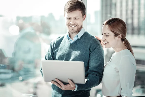 Tevreden verantwoordelijk mens permanent en houden de laptop. — Stockfoto