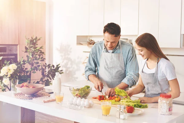 Snäll tonåring flicka gör att hjälpa sin far i köket — Stockfoto