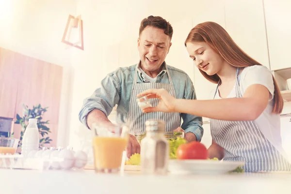 Leende man ser vad är dottern gör — Stockfoto