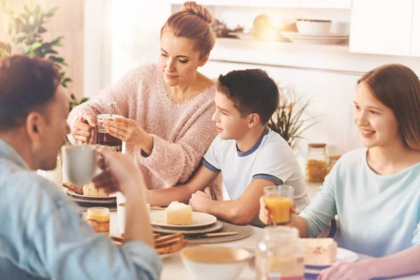 Mãe atenta preparando chá saboroso para todos — Fotografia de Stock