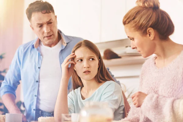 Scared girl looking angrily at her mother