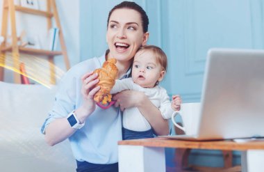 Bir kruvasan tutan mutlu memnun kadın