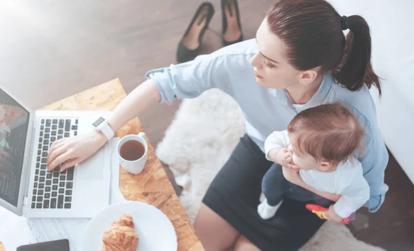 Top view of a working mother sitting at home — Stock Photo, Image