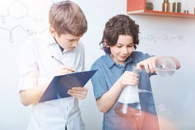 Öğrenciler kimyasal deneme sırasında veri toplama