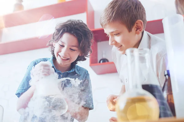 Возбужденные дети улыбаются во время работы с набором химикатов — стоковое фото