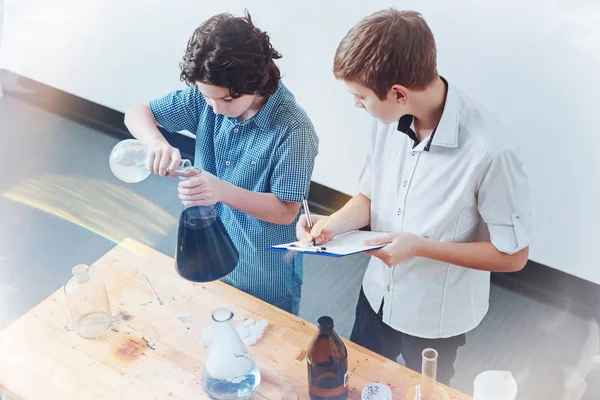 Bovenaanzicht van leerlingen uitvoeren experiment in laboratorium van de school — Stockfoto