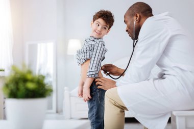 Özenli erkek Doktor muayene çocuk stetoskop ile