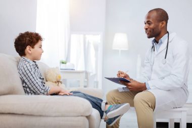 Neşeli erkek doktor sorgulama çocuk