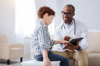 Mutlu erkek doktor gösteren çocuk tablet