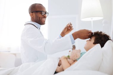 Mutlu erkek doktor sıcaklık kontrol
