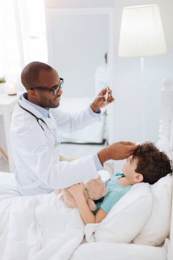 Güçlü erkek doktor çocuklar sıcaklık tahmin etme