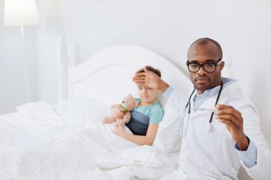 Mutlu erkek doktor çocuklar sıcaklık belirleme