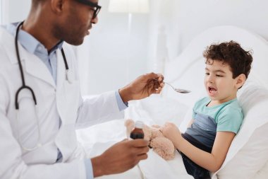 Erkek doktor öksürük ilacı veren konsantre