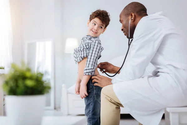 Atento médico masculino examinando niño con estetoscopio — Foto de Stock