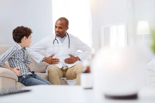 Focused male doctor and boy discussing symptoms — Stock Photo, Image