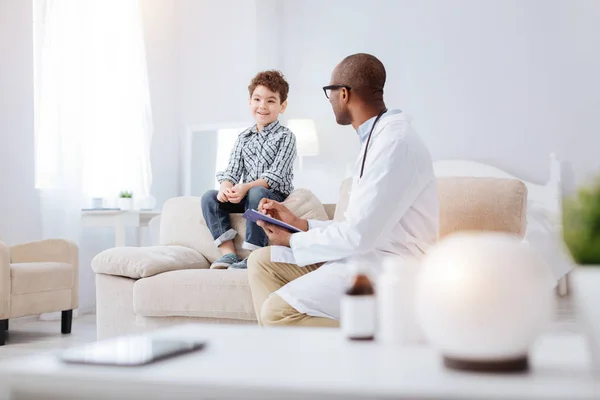 Skillful male doctor writing down symptoms — Stock Photo, Image