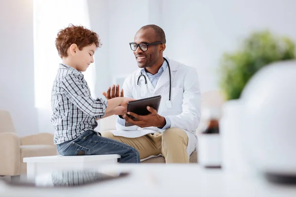 Médico masculino optimista compartiendo su trabajo con el niño — Foto de Stock