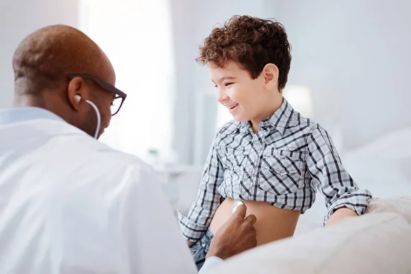 Médico masculino hábil diagnosticando niño con estetoscopio — Foto de Stock