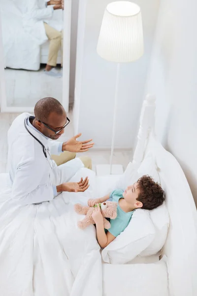 Encantador médico varón mostrando enfoque chico enfermo — Foto de Stock