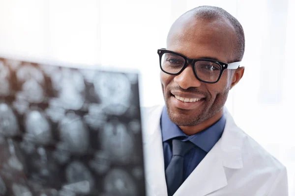 Satisfied male doctor reviewing brain imaging