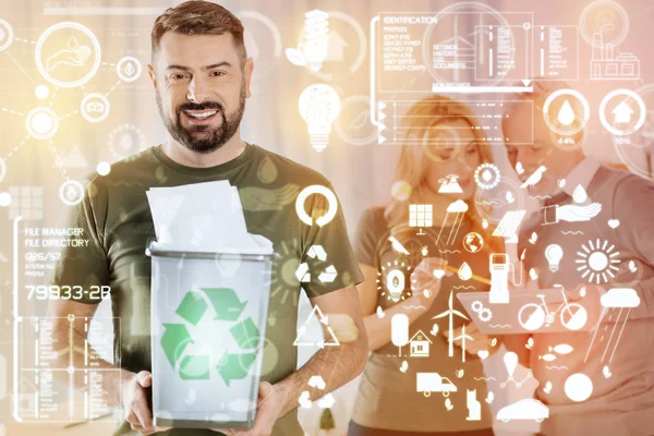 Optimistic man holding a rubbish bin and asking people to recycle paper